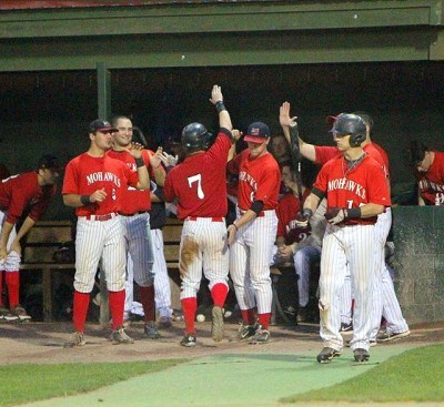 Jordan Ebert (Auburn) is welcomed back to the dugout after scoring in the fifth inning